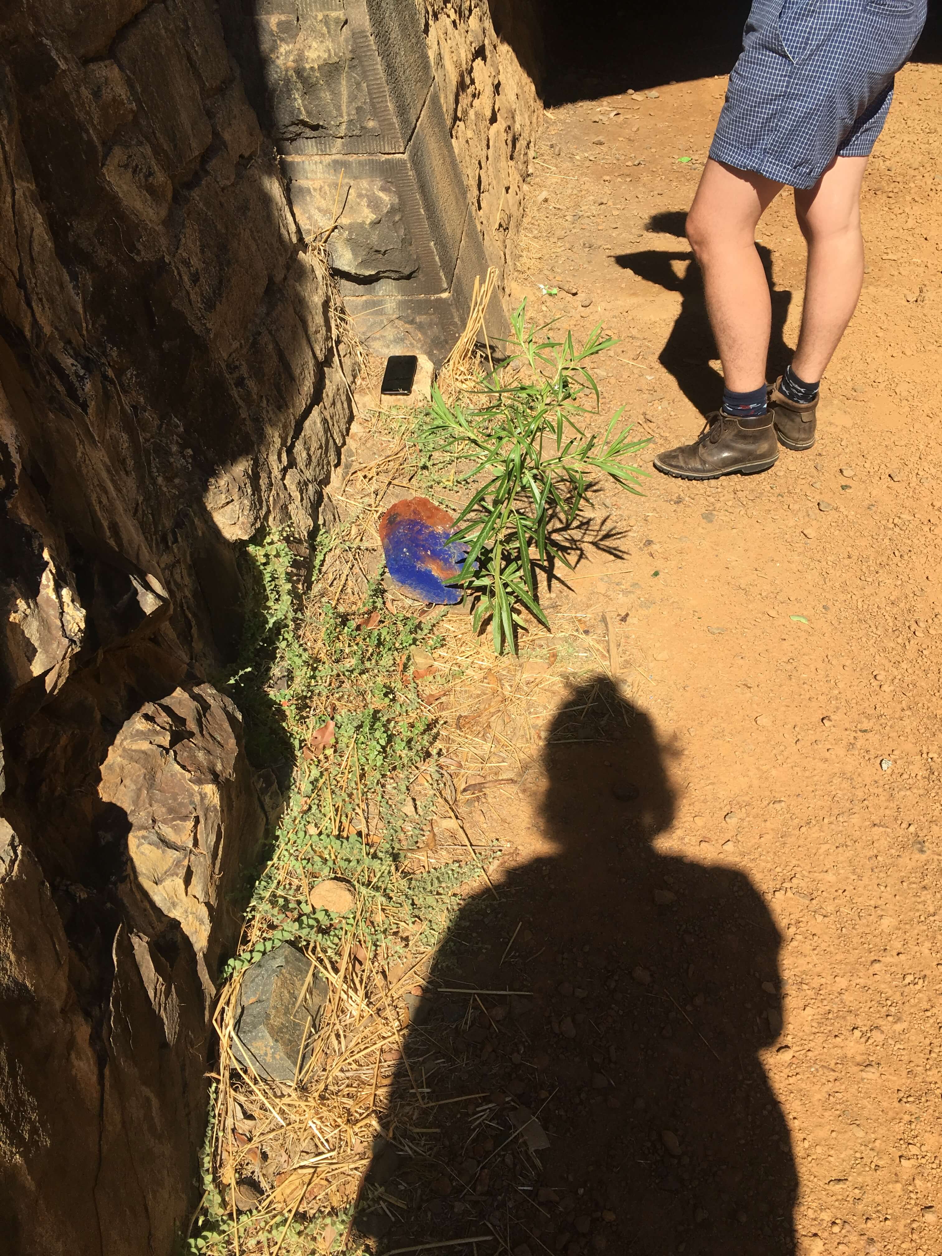 standing at the entrance of Swan View tunnel next to a painted blue rock and Be Gosper's boots